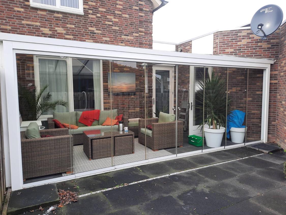 Veranda met glazen schuifwanden en zitgroep, schoon glas